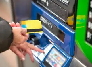 a person using a credit card to pay for a machine
