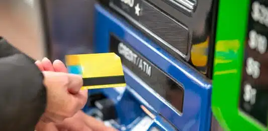 a person using a credit card to pay for a machine
