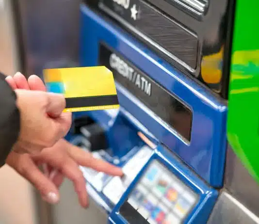 a person using a credit card to pay for a machine