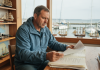 Comment choisir la bonne assurance pour son bateau ? Homme en windbreaker bleu examine documents d'assurance bateau