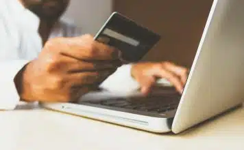 Comprendre le plafond de virement crédit agricole : tout ce que vous devez savoir ! person using laptop computer holding card