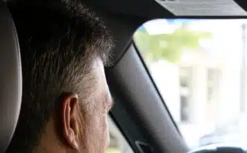 un homme en chemise dans sa voiture